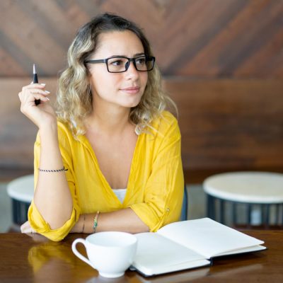 pretty-curly-young-woman-writing-notes-startup-project